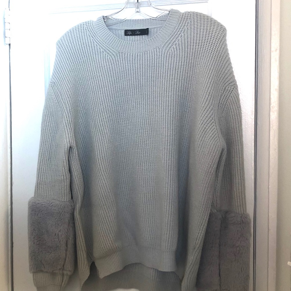 Sweater with faux fur cuffs.